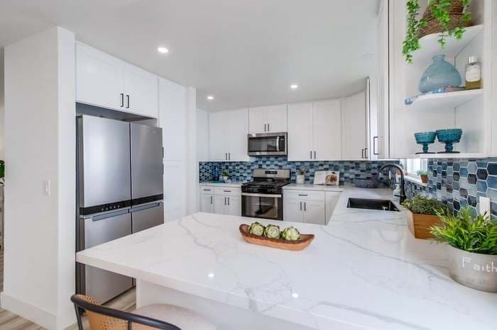 Picture of a newly remodeled kitchen with new granite countertops and white cabinets